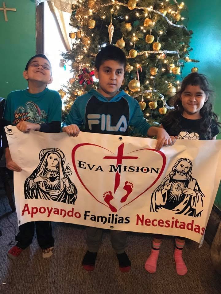 Niños sosteniendo el banner de Eva Misión.